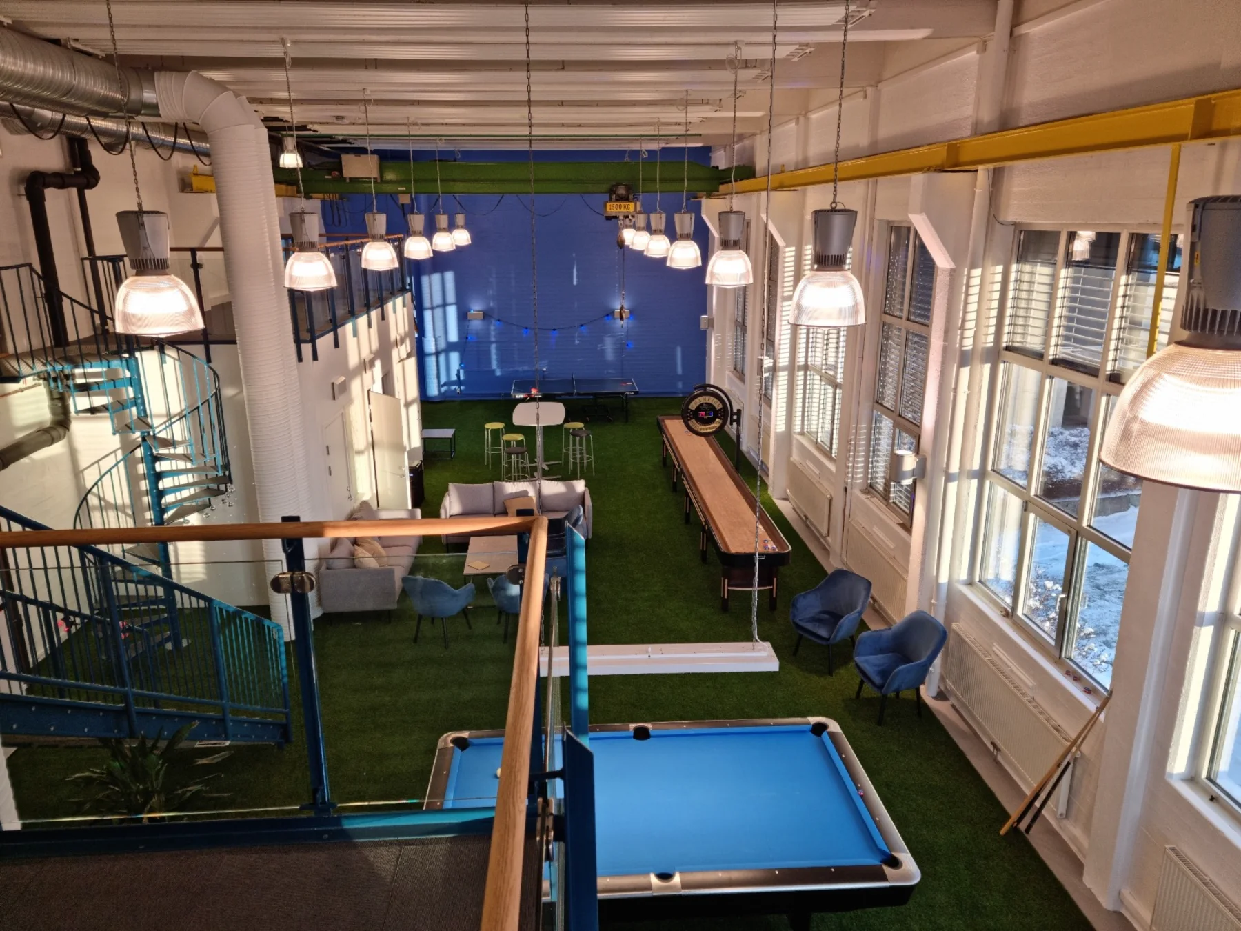 O espaço construído: vista do mezanino sobre a área de grama, com bilhar, shuffleboard e estar