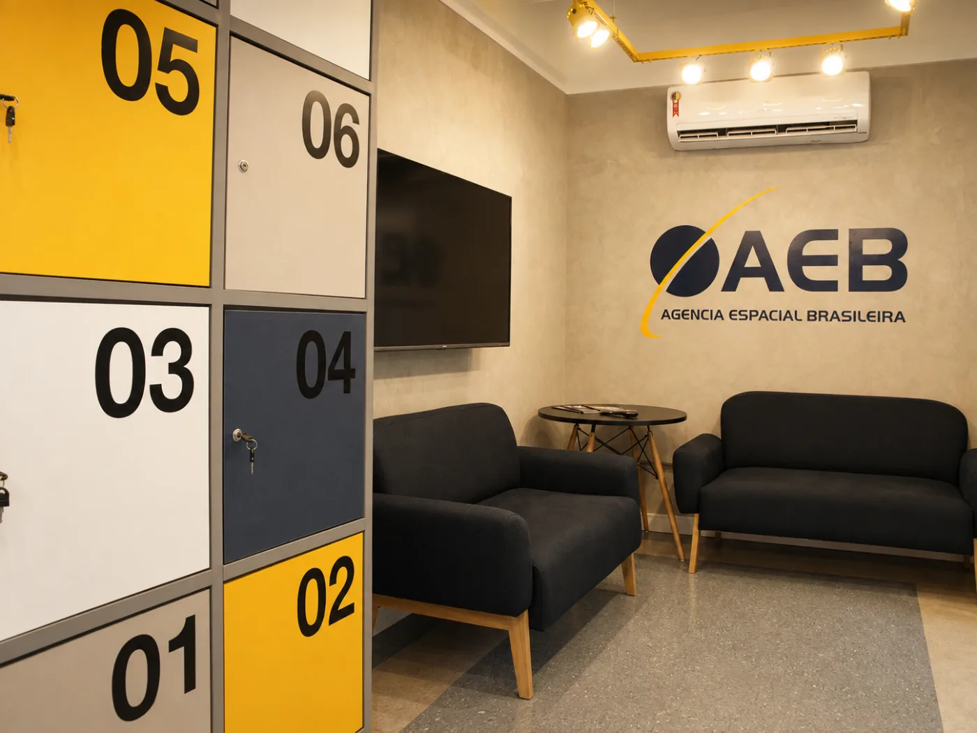 AEB Espaço de Inovação: recepção com armários compartilhados e área de espera junto à comunicação institucional