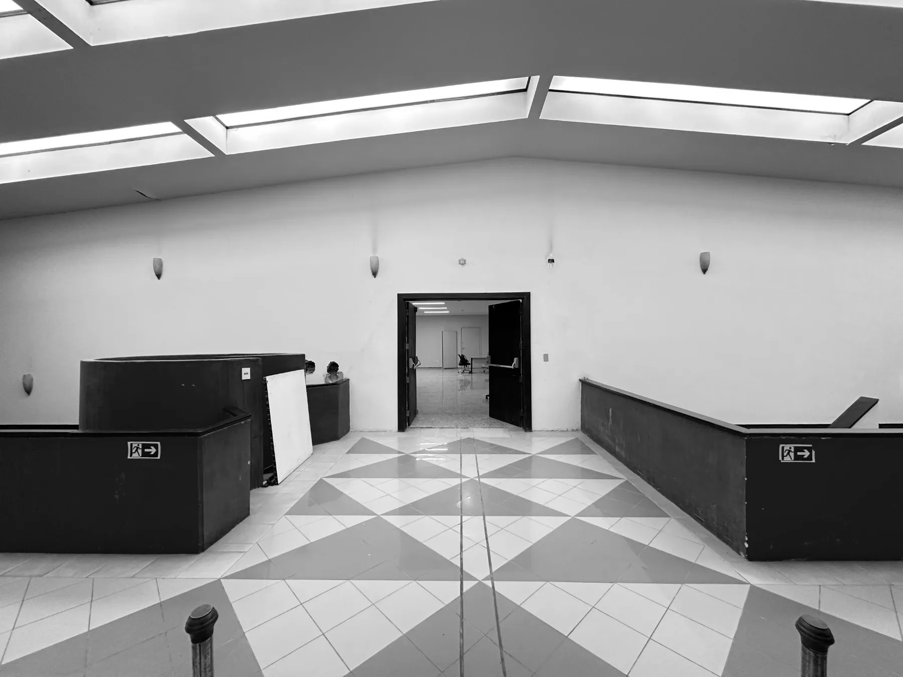 Hall principal antes da intervenção: muretas vermelhas desgastadas, arandelas antigas e porta de madeira escura no acesso ao pavimento