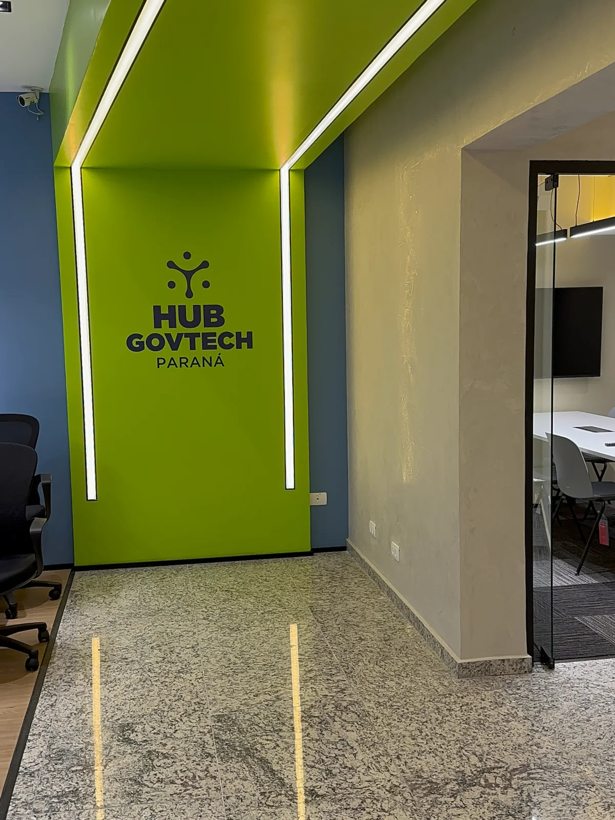Portal verde iluminado por perfis de LED, com a marca Hub GovTech Paraná aplicada ao fundo