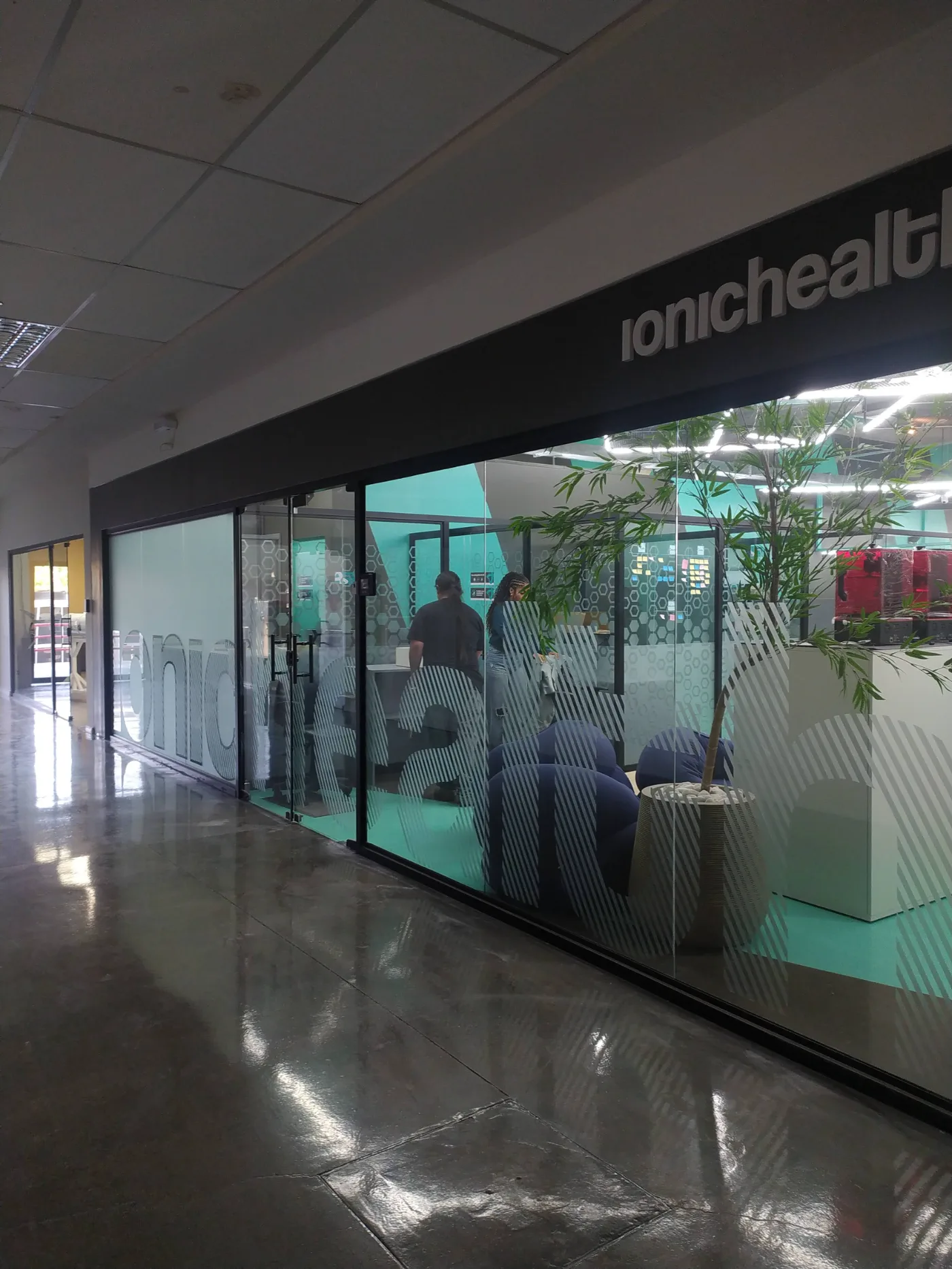 Vitrine da expansão vista da circulação, com a testeira sinalizada e a marca aplicada no vidro