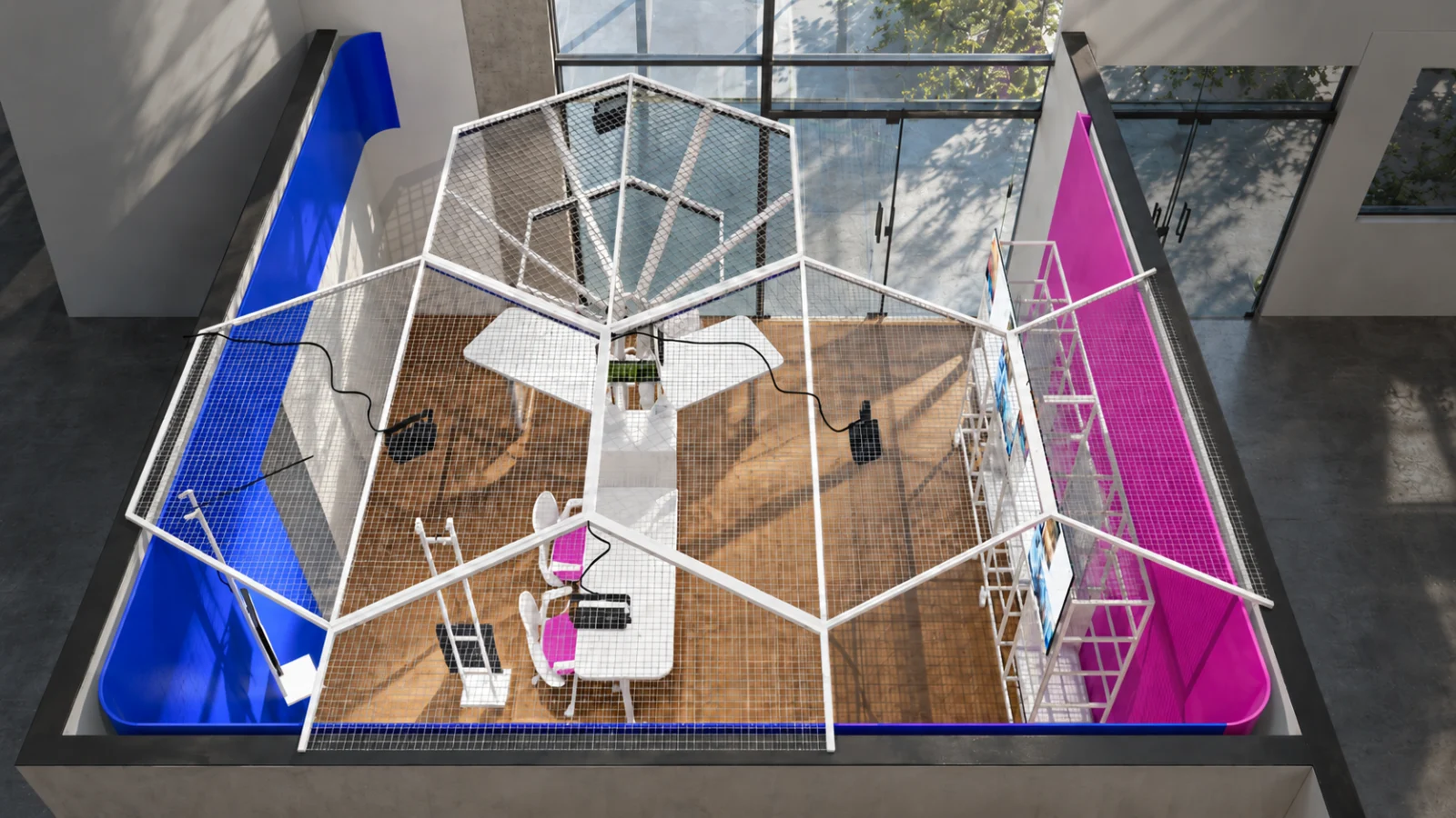 Vista superior do Living Lab: a estrutura hexagonal aberta sobre as bancadas, entre as superfícies azul e magenta