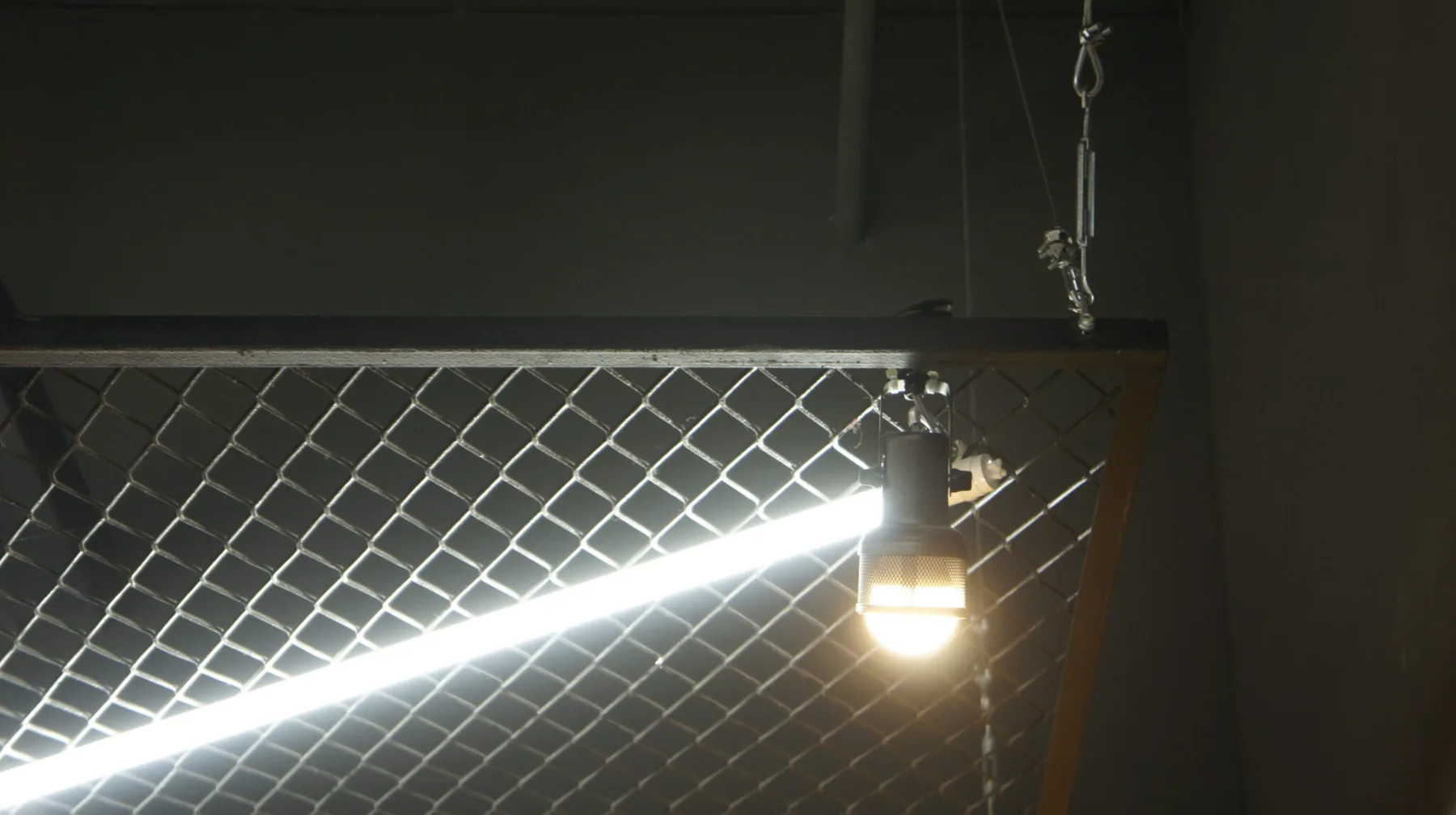 Detalhe do plano de tela expandida suspenso por cabos, com spot e tubular acoplados