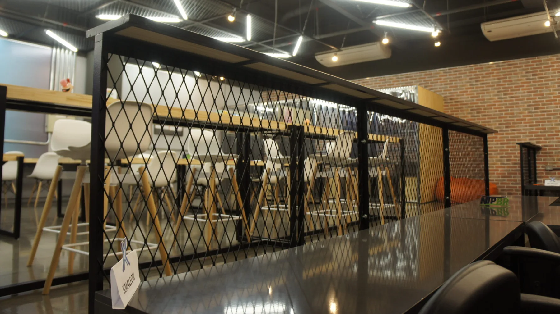 Bancada de trabalho contínua delimitada por painel em tela expandida preta