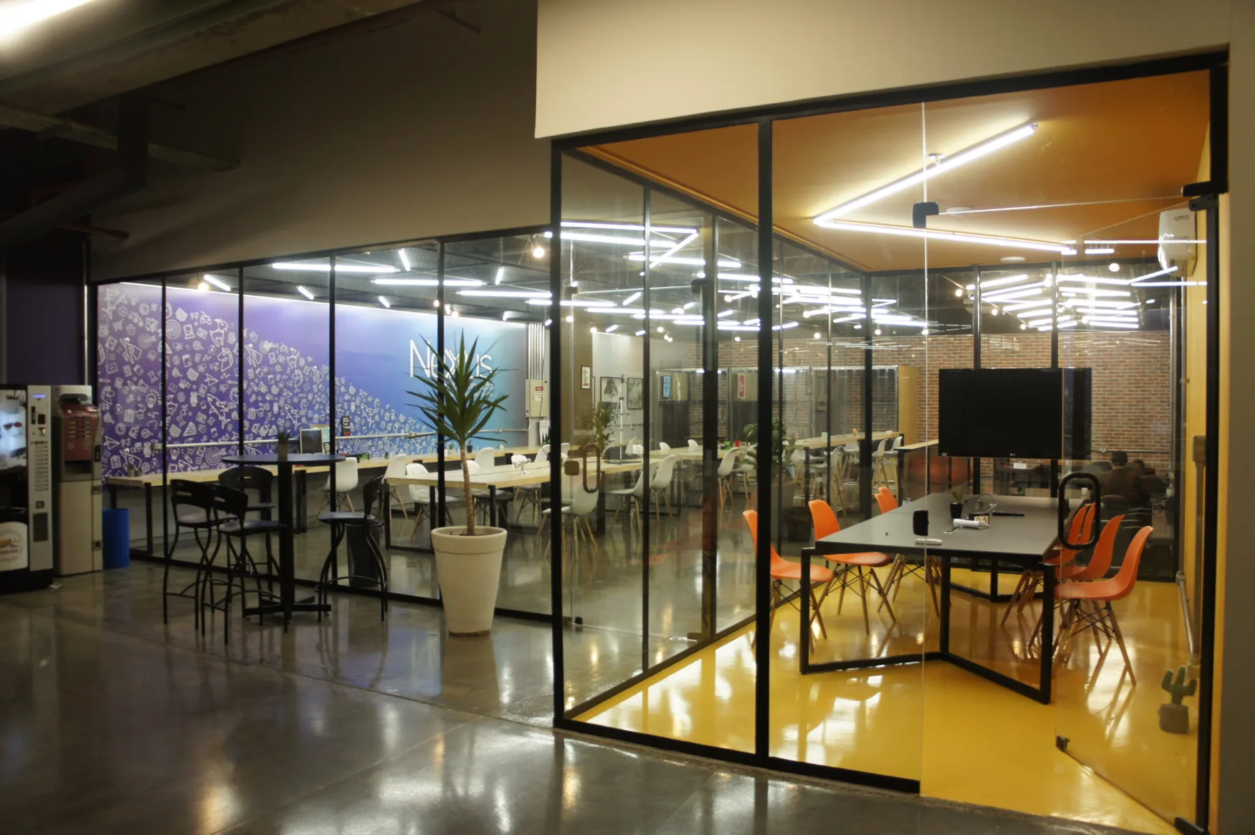 Vista do salão a partir da circulação, com a sala amarela em primeiro plano e o painel gráfico azul ao fundo