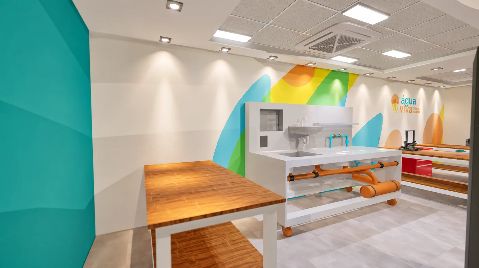 Bancada técnica móvel com pia e tubulações aparentes, diante do grafismo colorido do laboratório