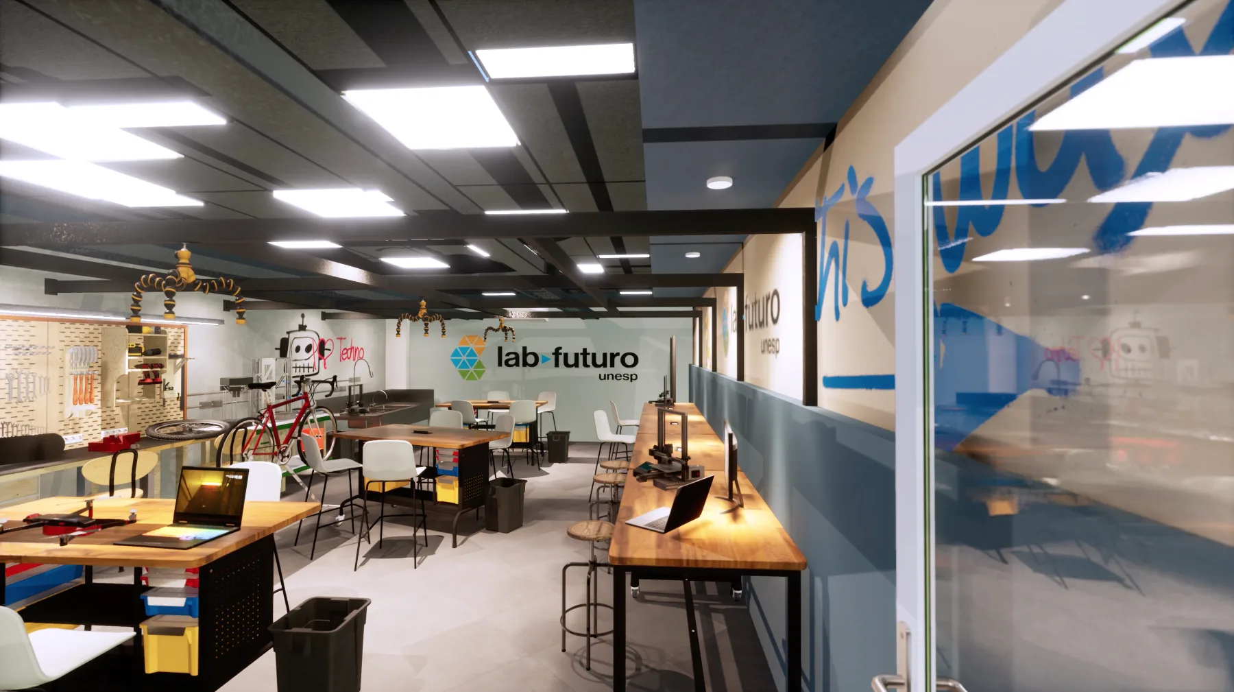 Espaço maker do LAB do Futuro: bancadas de madeira com impressoras 3D, oficina de ferramentas ao fundo e a marca aplicada na parede