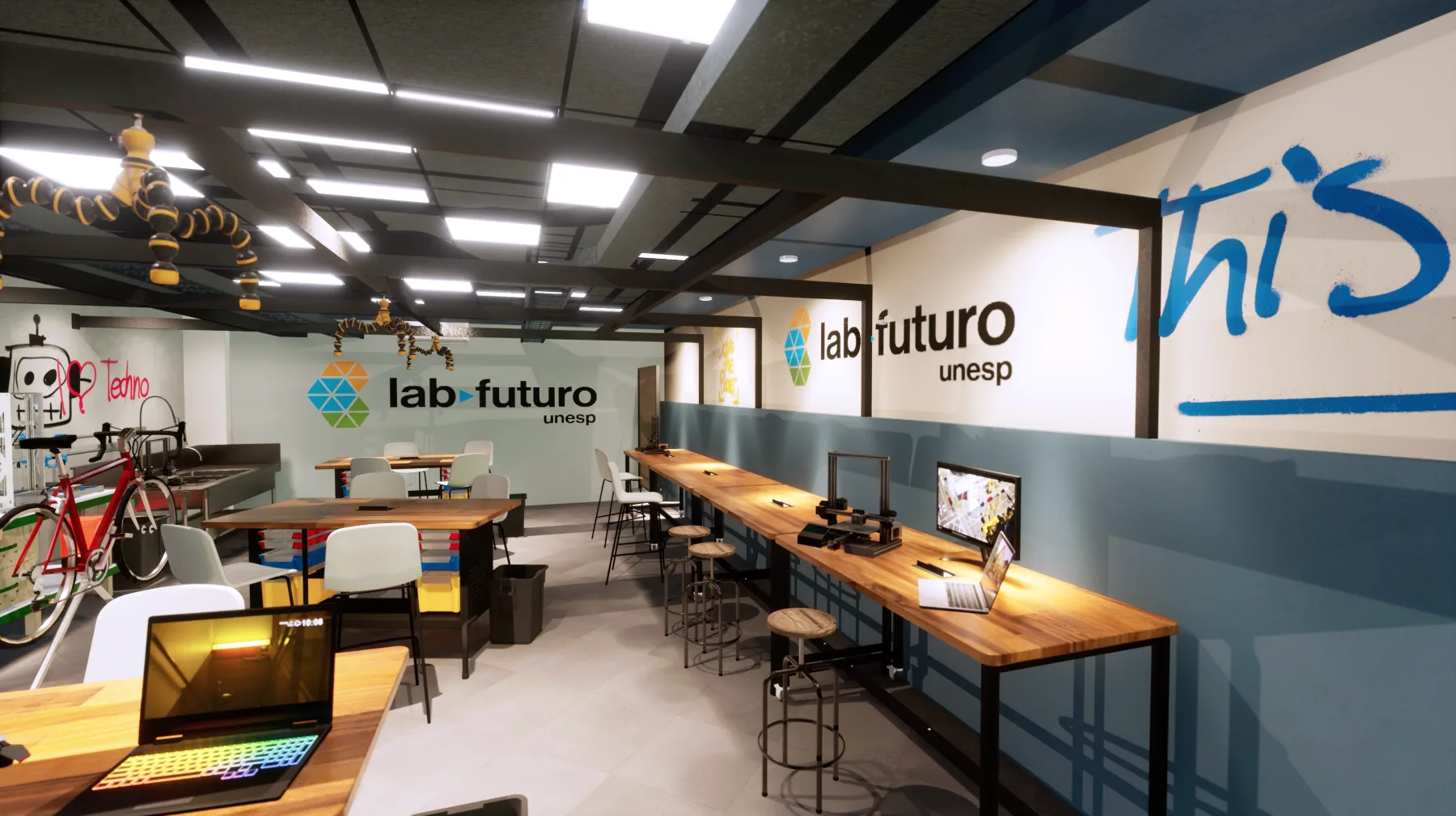 Bancada longa de trabalho ao lado do espaço maker, com a marca repetida na parede e grafismos em azul